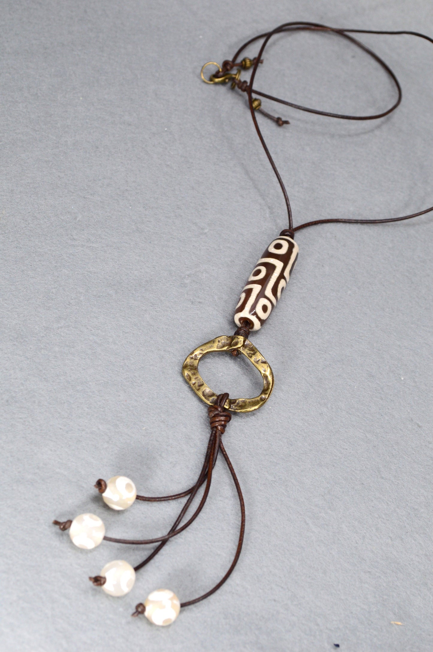 Long Leather cord necklace with agate DZI bead design, Artisan-crafted hippie Ring pendant, tribal-inspired. Estibela design.