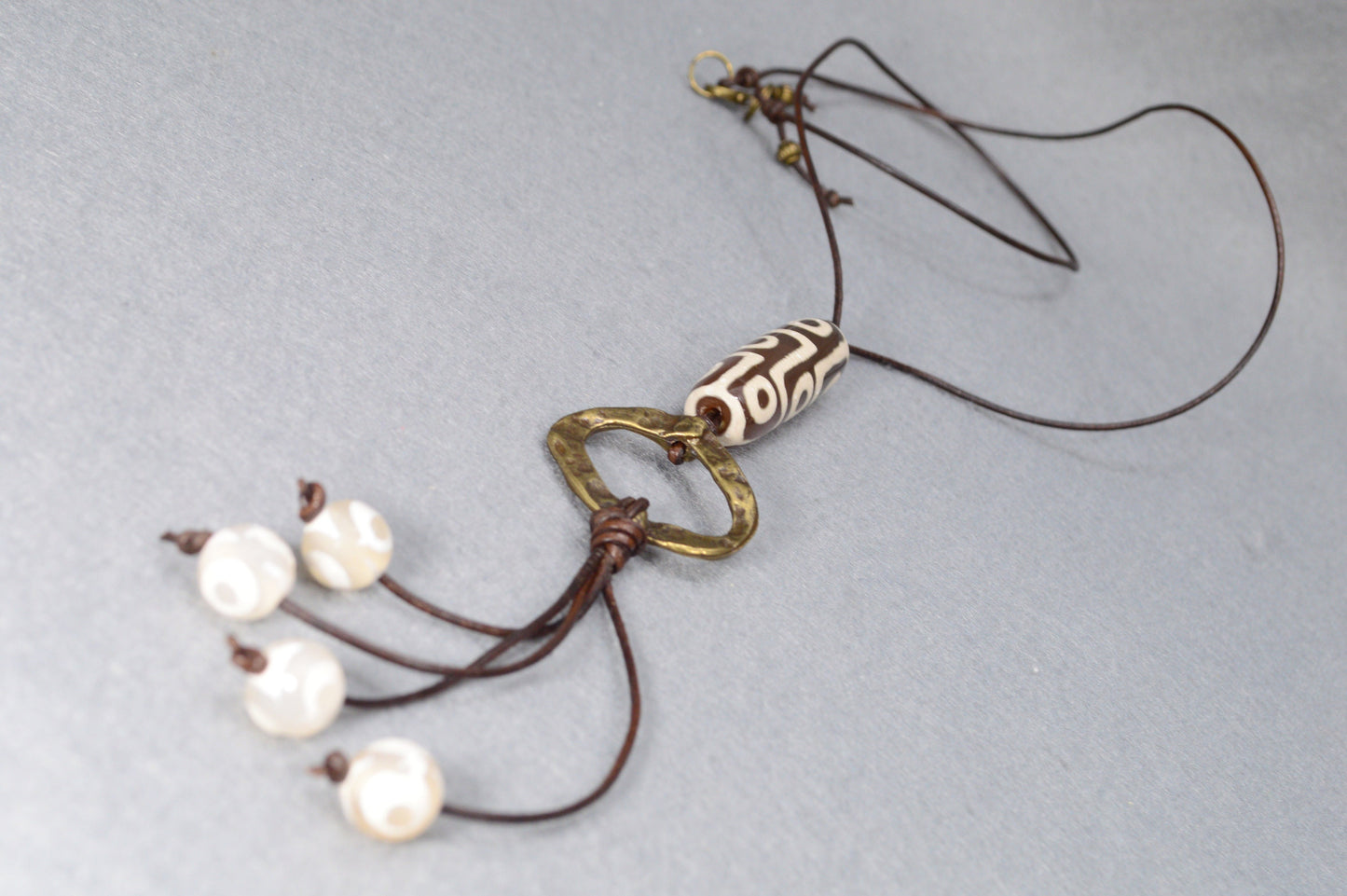 Long Leather cord necklace with agate DZI bead design, Artisan-crafted hippie Ring pendant, tribal-inspired. Estibela design.