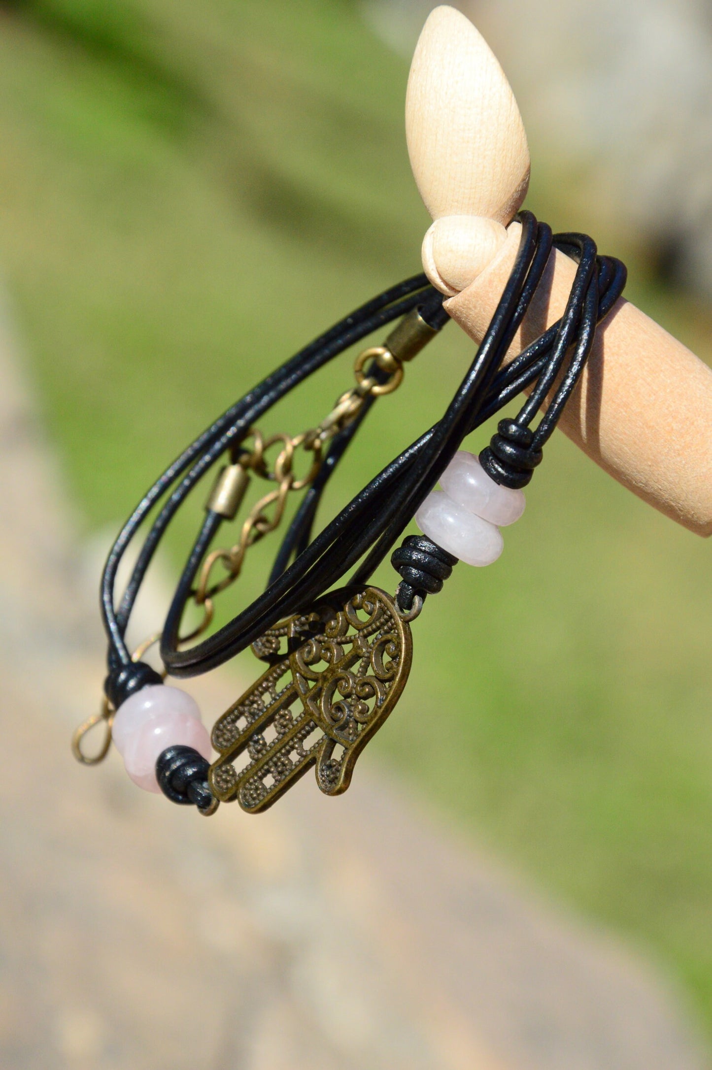 Black Leather Boho Bracelet with Bronze Hamsa Hand Charm and Natural Stone Decoration.