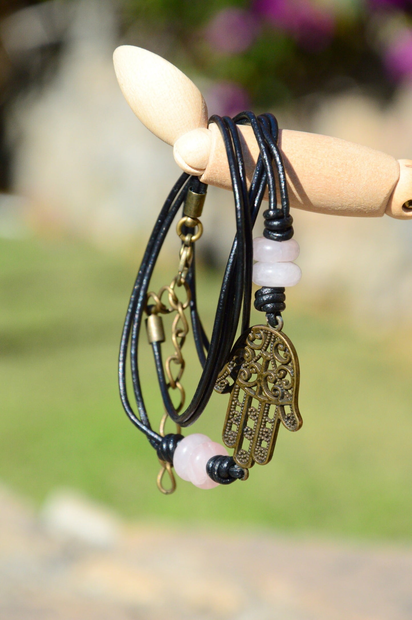 Black Leather Boho Bracelet with Bronze Hamsa Hand Charm and Natural Stone Decoration.