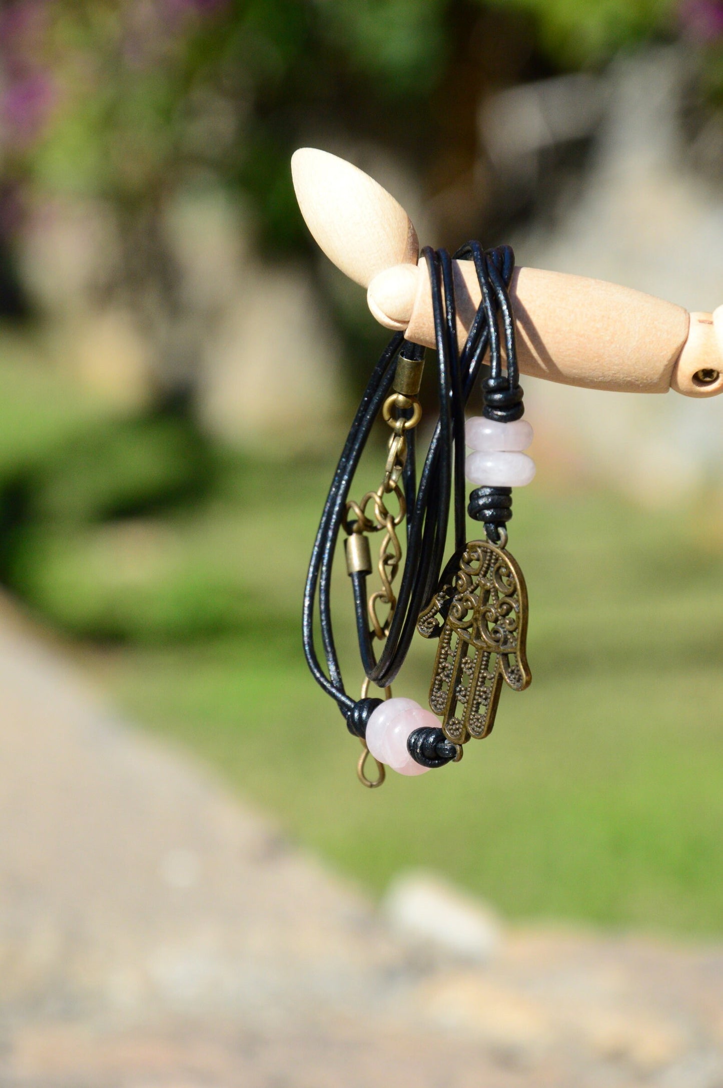 Black Leather Boho Bracelet with Bronze Hamsa Hand Charm and Natural Stone Decoration.