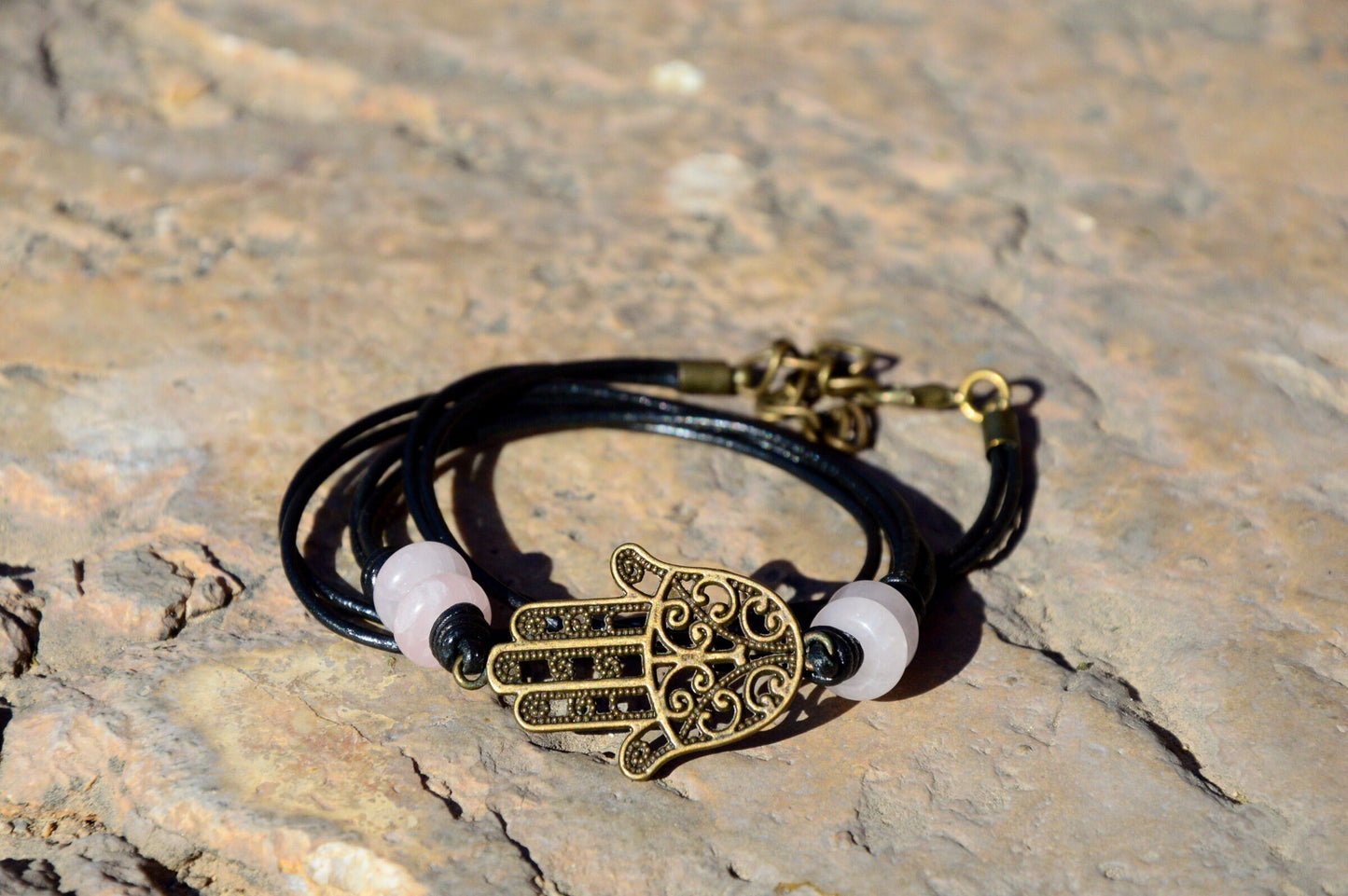 Black Leather Boho Bracelet with Bronze Hamsa Hand Charm and Natural Stone Decoration.