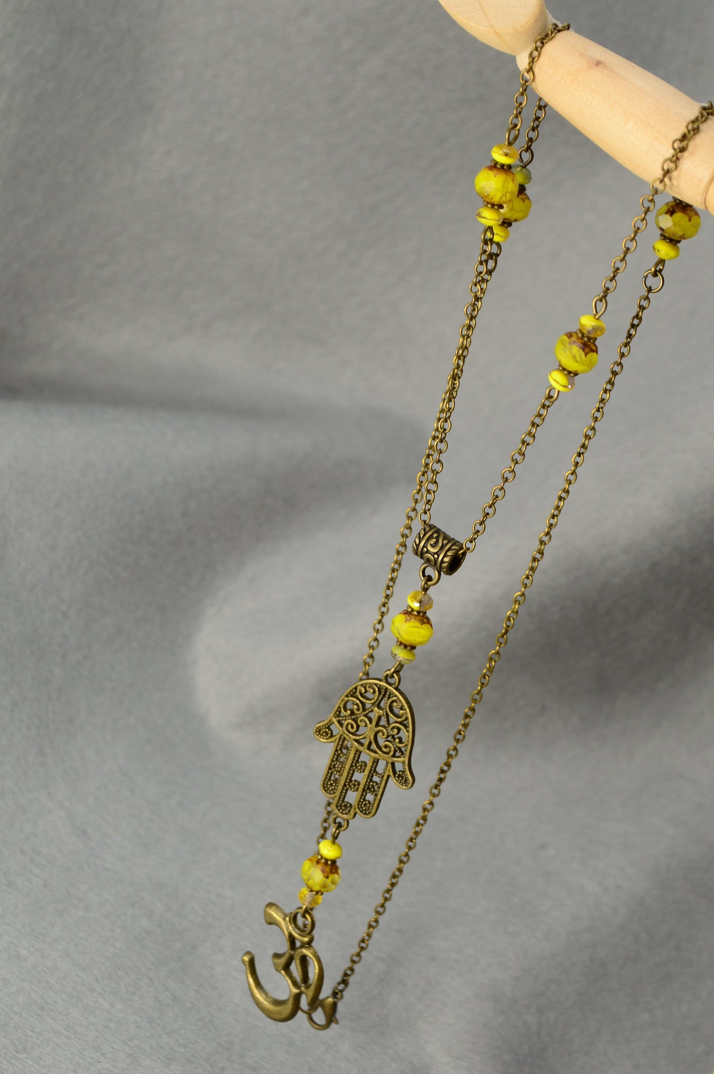 Hamsa hand & Ohm sympol pendant. Bronze Chain Necklace Adorned with Yellow Glass Beads and Spiritual Pendants