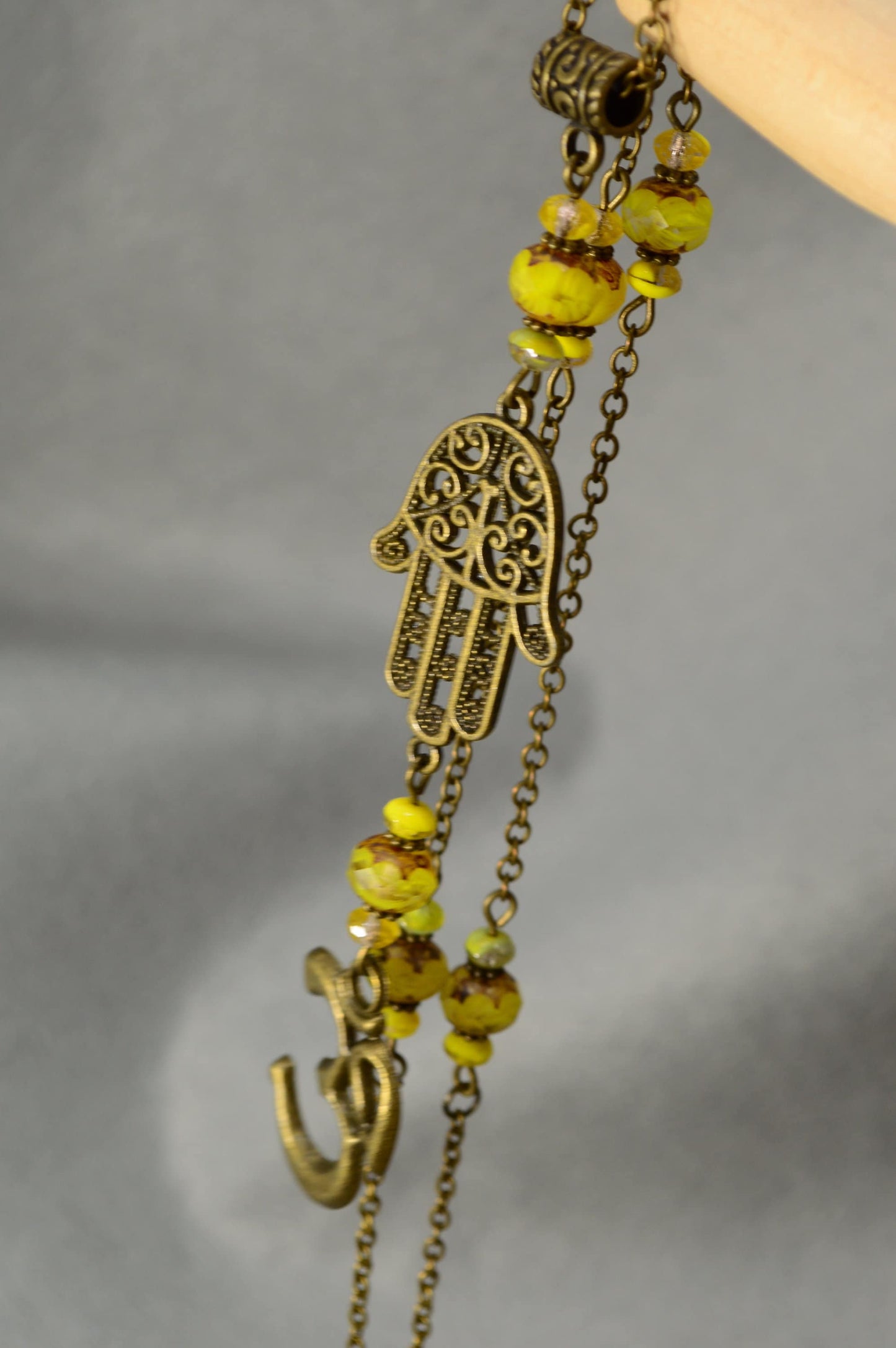 Hamsa hand & Ohm sympol pendant. Bronze Chain Necklace Adorned with Yellow Glass Beads and Spiritual Pendants