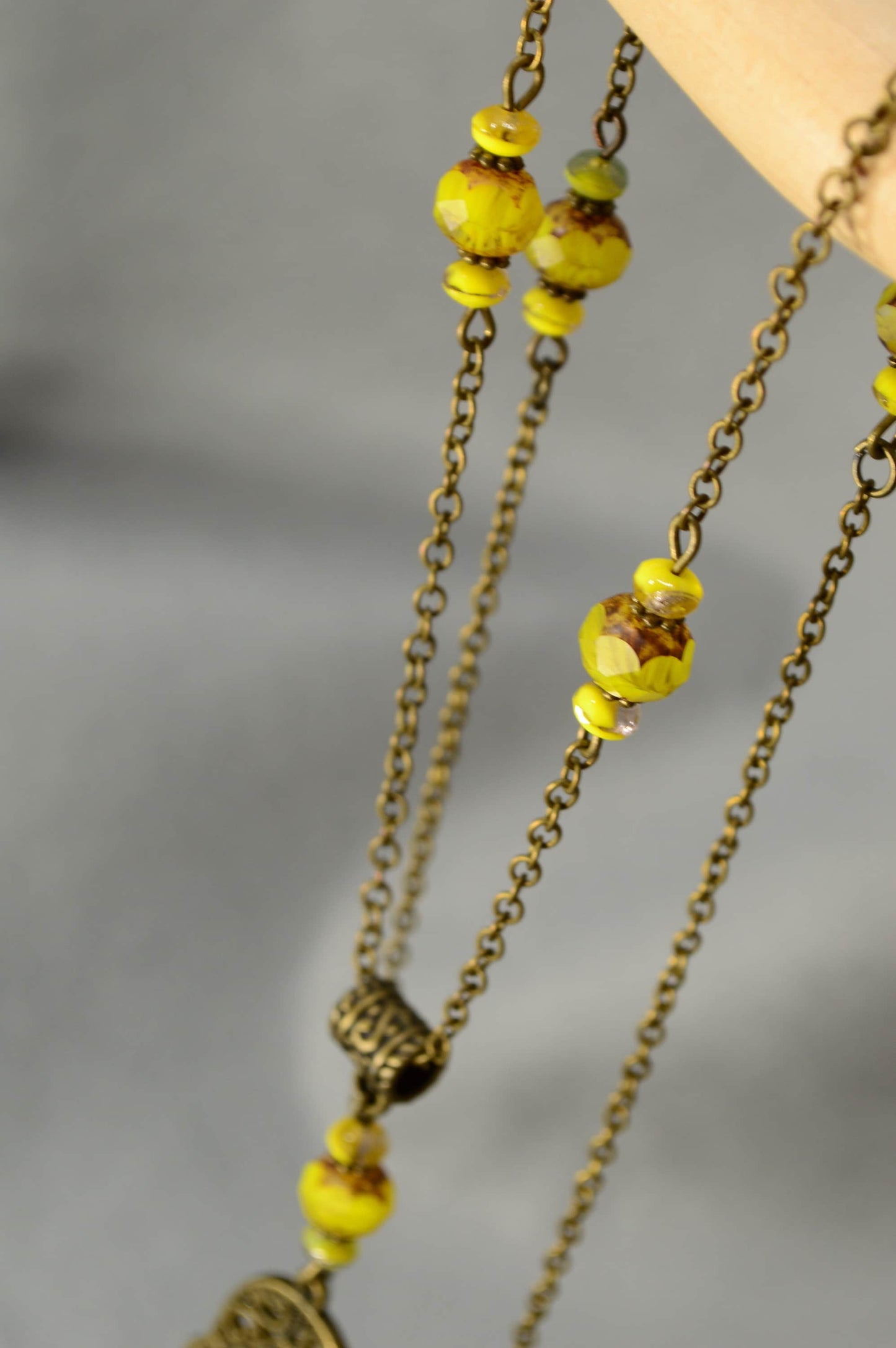 Hamsa hand & Ohm sympol pendant. Bronze Chain Necklace Adorned with Yellow Glass Beads and Spiritual Pendants