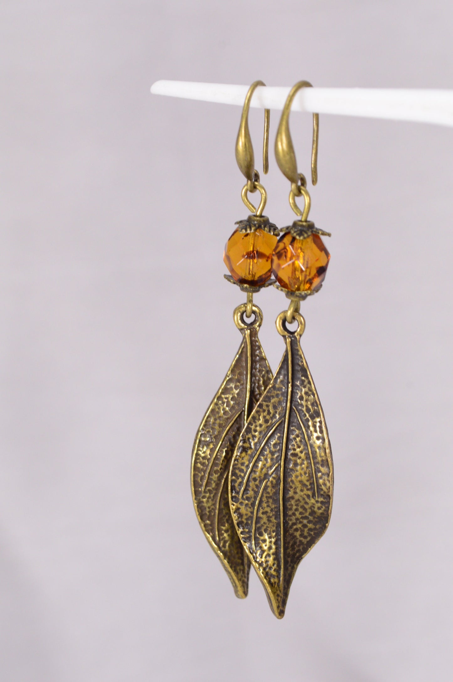 Bohemian Style Estibela Bronze Handmade Earrings with Dark Honey Czech Glass Bead and Twisted Leaf Pendant. 6.5cm - 2.4"