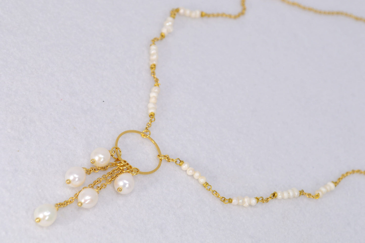 Elegant golden necklace adorned with freshwater pearls and baroque pearls in a unique triangular design. Estibela design.