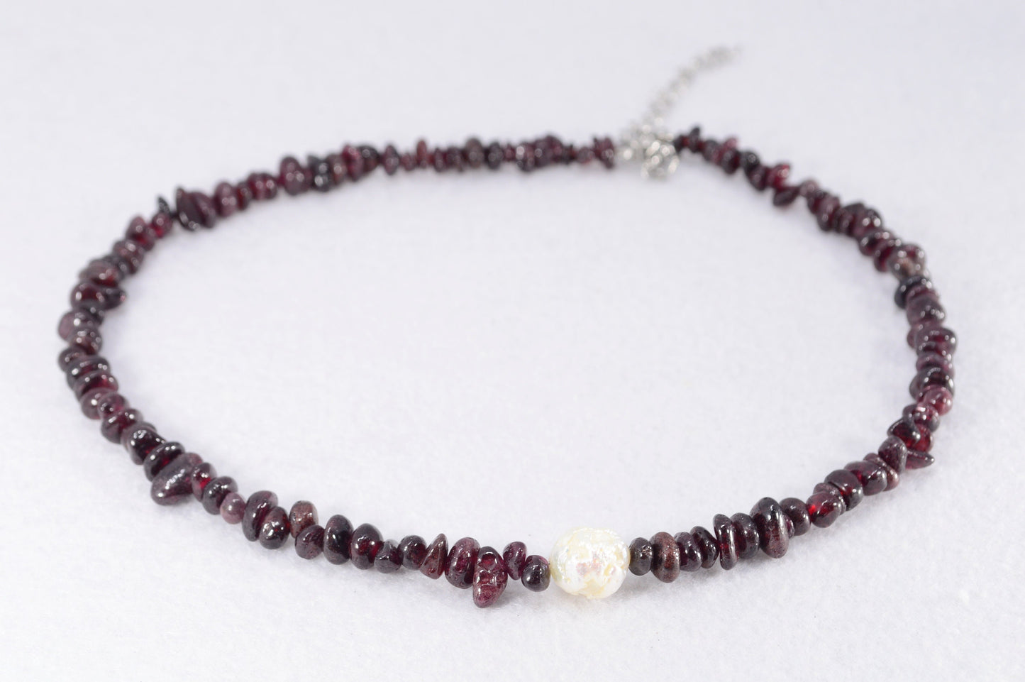 Garnet and stainless steel necklace with white baroque pearl, unique artisanal design perfect for elegant evening wear outings.