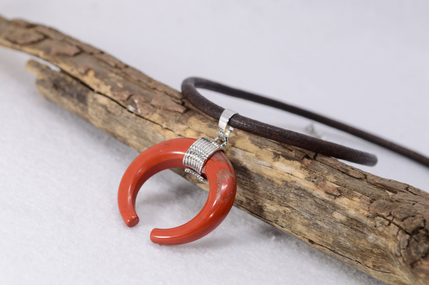 Estibela necklace with thick brown leather cord and moon-shaped pendant in Red Jasper or Blue Aventurine. Boho hippie design.