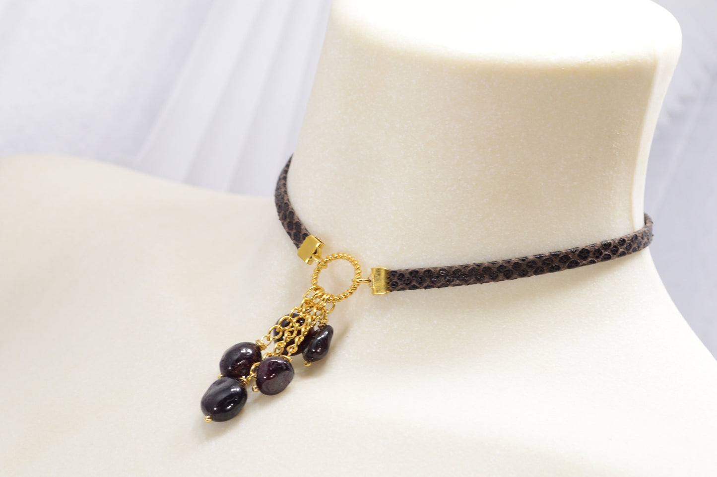 Brown leather choker with unique Estibela design. Stainless steel ring and cascading garnet beads. Limited edition.