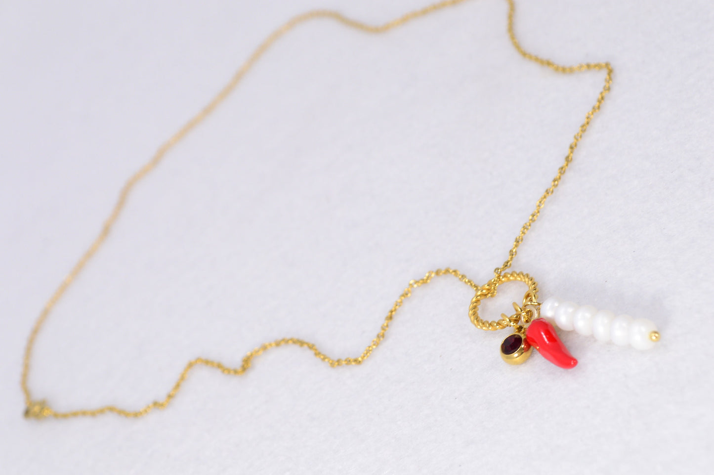 Red chili pepper necklace with gold stainless steel chain, red glass bead, and river pearls, perfect for edgy, boho-chic fashionistas