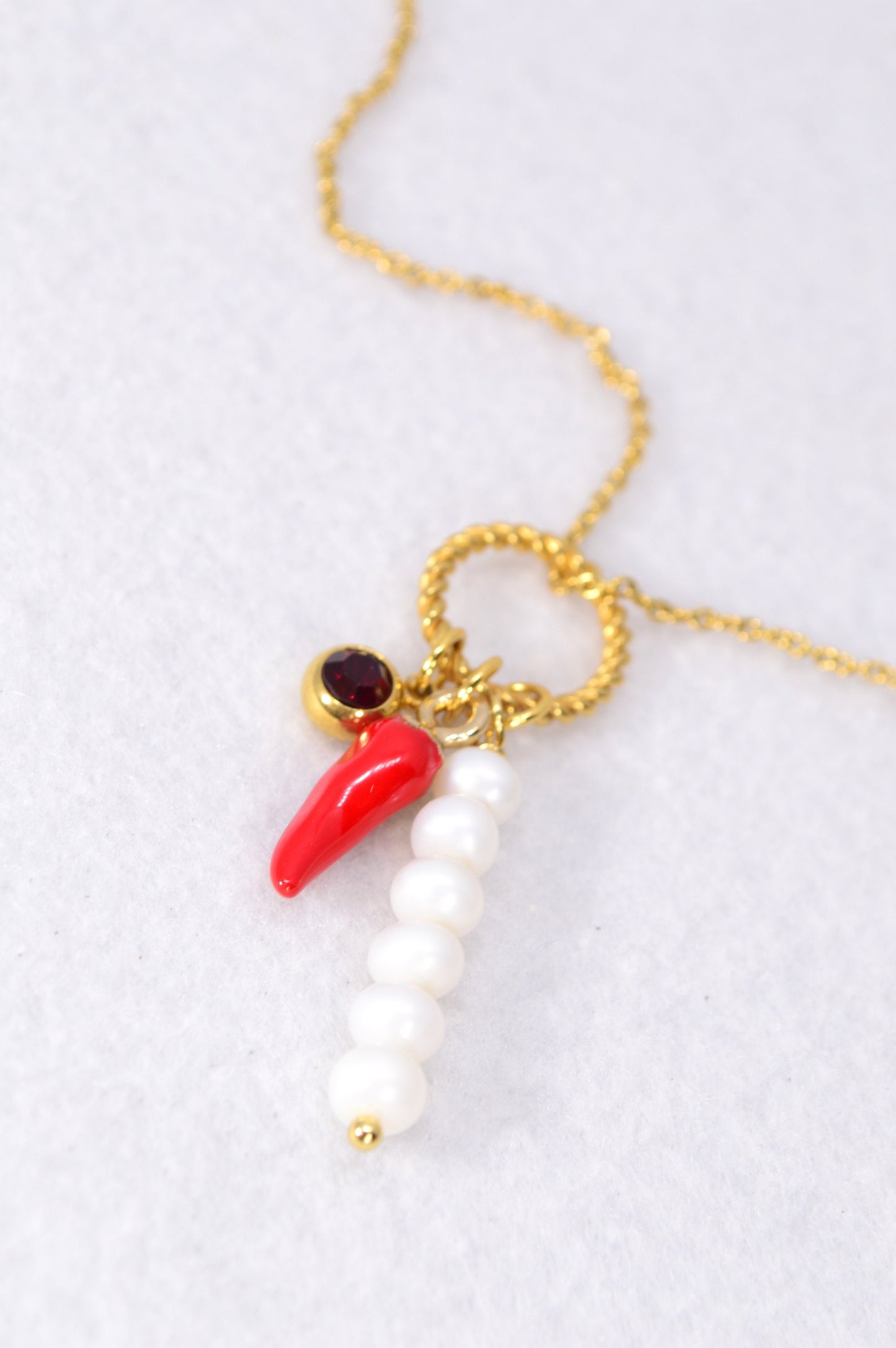 Red chili pepper necklace with gold stainless steel chain, red glass bead, and river pearls, perfect for edgy, boho-chic fashionistas