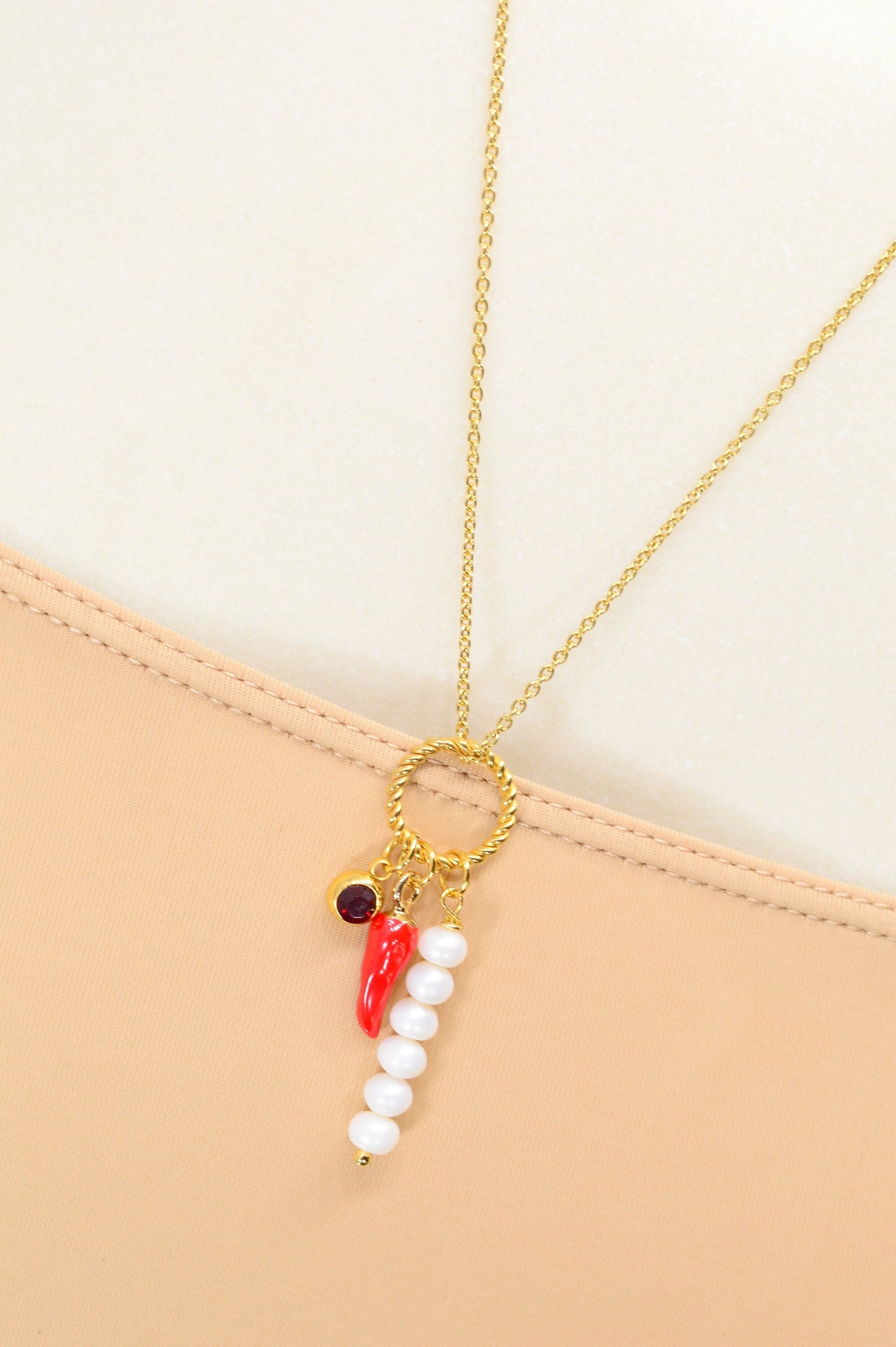 Red chili pepper necklace with gold stainless steel chain, red glass bead, and river pearls, perfect for edgy, boho-chic fashionistas