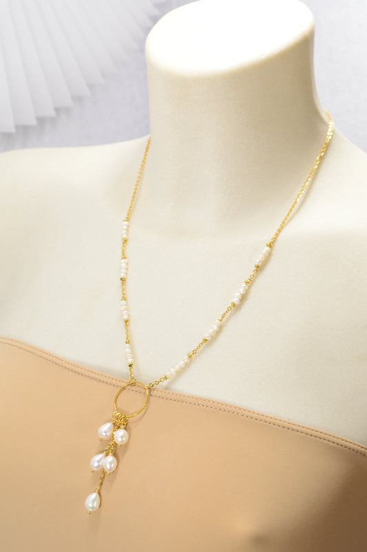 Elegant golden necklace adorned with freshwater pearls and baroque pearls in a unique triangular design. Estibela design.