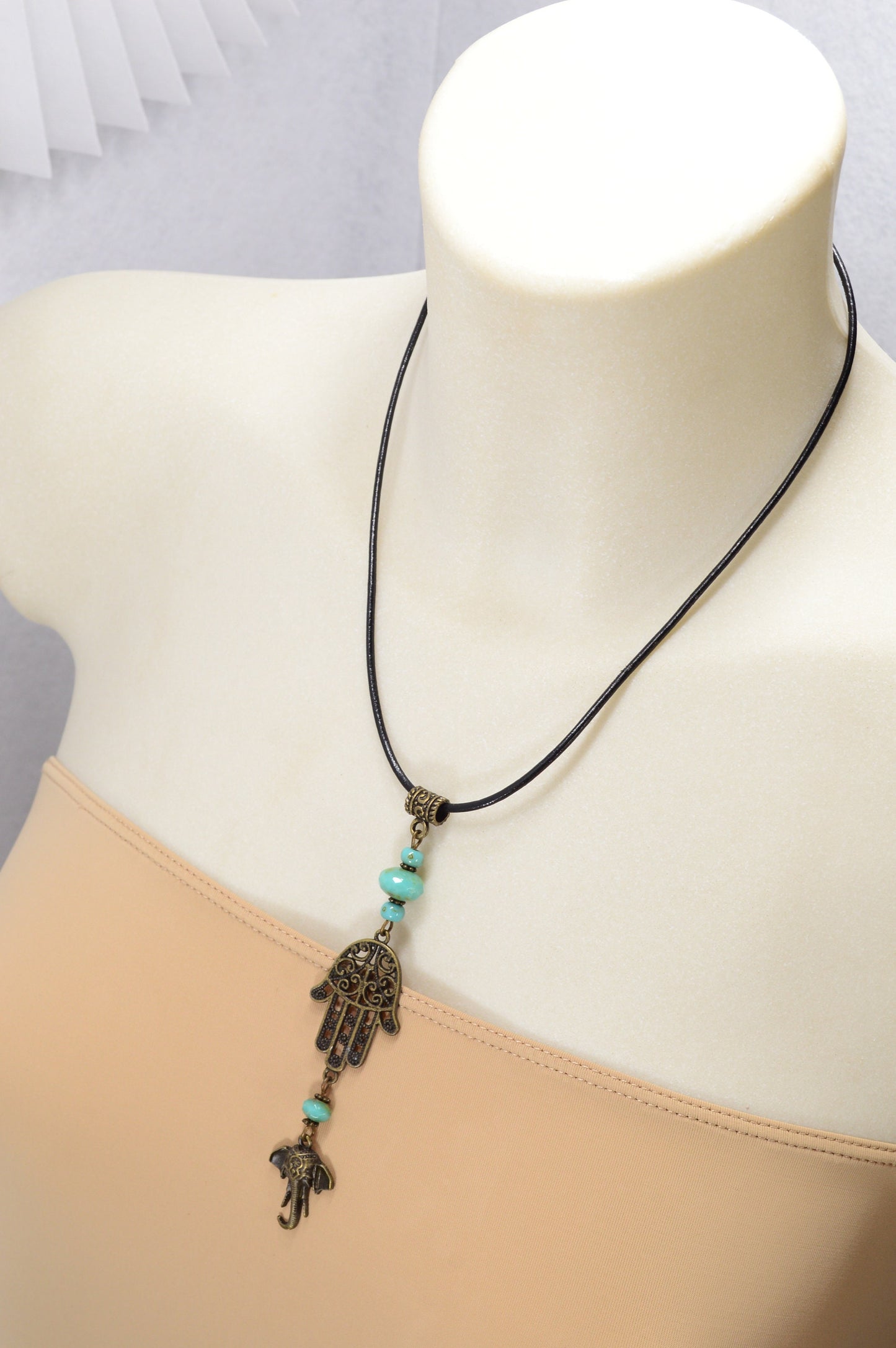 Boho chic leather cord with intricate bronze pendant & sea green Czech glass, perfect for adding flair to any outfit. Estibela design.