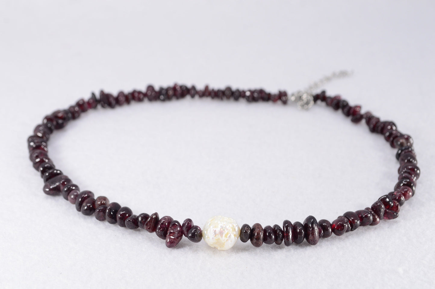 Garnet and stainless steel necklace with white baroque pearl, unique artisanal design perfect for elegant evening wear outings.