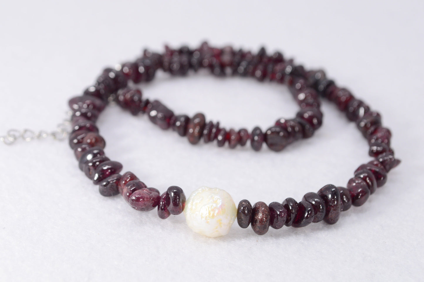 Garnet and stainless steel necklace with white baroque pearl, unique artisanal design perfect for elegant evening wear outings.